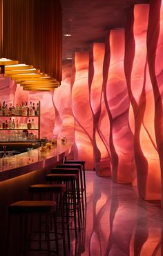 the interior of a bar with many stools and colorful wall paper behind it,