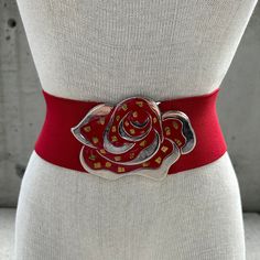 80s red stretch belt with chunky buckle, abstract round enamel buckle, red and gold tone,maximalist eclectic girl, retro waist accessory,  Elevate your ensemble with our 80s Red Stretch Belt, an emblem of maximalist elegance for the eclectic girl. This wide elastic belt is not just an accessory; it's a bold fashion statement that transcends trends. The centerpiece of this masterpiece is the enamelled lotus flower buckle, a symbol of purity and enlightenment, meticulously crafted in red and silver tone with a mesmerizing abalone inlay. The chunky buckle takes center stage, commanding attention with its intricate detailing. The lotus flower, deeply rooted in symbolism, infuses the accessory with a sense of spiritual grace and resilience. The vibrant red hue symbolizes passion and vitality, w Maximalist Eclectic, Red And Silver, Elastic Belt, Stretch Belt, Suspender Belt, Eclectic Style, Center Stage, Red And Gold, Bold Fashion