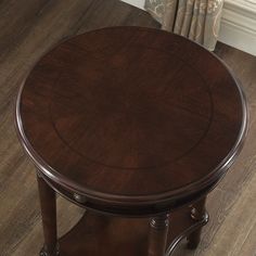 a round wooden table sitting on top of a hard wood floor