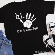 Hi five! It's your 5th birthday! Celebrate this milestone birthday with a stylish Hi Five I'm a Handful Handprint Birthday t-shirt. SIZE: 2T 3T 4T 5/6 XS youth S youth M youth L youth XL youth T-SHIRT COLOR: red navy black LETTER COLOR: white MATERIAL: 100% preshrunk cotton heat transfer vinyl CARE INSTRUCTIONS: DO NOT dry clean wash inside out in cold or warm water use mild detergents dry on low setting DO NOT iron directly onto design ••••••••••••••••••••••••••••••••••••••••••••••••••••••••••• Family Matching Black Screen Print T-shirt, Black Family Matching T-shirt With Screen Print, Black T-shirt With Name Print For Family Matching, Black Family Matching T-shirt With Name Print, Father's Day Black T-shirt With Funny Print, Black Top With Text Print For Birthday, Black Tops With Text Print For Birthday, Casual Black T-shirt For Birthday, Black T-shirt With Name Print For Birthday