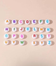 letters and numbers made out of candy are arranged on a pink surface with the letter's lowercases