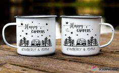 two white campers mugs sitting on top of a wooden table