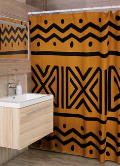 a bathroom with a yellow and black shower curtain next to a white sink under a mirror