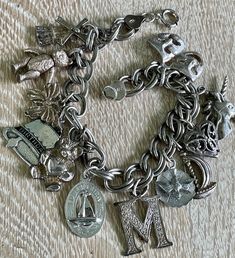 FREE SHIPPING to all US addresses!  This listing is for a vintage sterling silver charm bracelet. There are two articulated charms with moving parts--a teddy bear and a windmill. Also 10 other rigid charms.  All of the charms and the bracelet are sterling silver. Most are marked. It weighs 38.9 grams (approx. 1.4 oz) and is 8" long. A fun eclectic piece. Has a great patina but could be polished if so desired. In excellent vintage condition. Vintage Sterling Silver Bracelet With Charm, Sterling Silver Bracelets With Dangling Charms For Collectors, Metal Dangling Charms For Collectibles, Collectible Silver Bracelet With Vintage Charm, Vintage Hallmarked Sterling Silver Charm Bracelet, Antique Sterling Silver Charms For Collectible, Vintage Silver Engraved Charm Bracelet, Antique Sterling Silver Charms For Collectors, Antique Sterling Silver Charm Bracelets