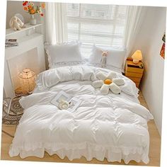 a bed with white comforters and pillows on it