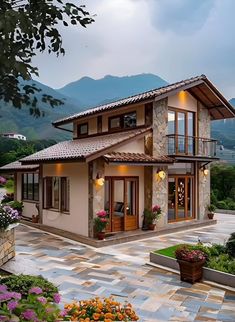 a large house sitting in the middle of a lush green field with mountains in the background