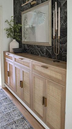 a room with a large mirror on the wall next to a rug and wooden cabinets