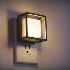 a light that is on the side of a wall with a square shaped light fixture