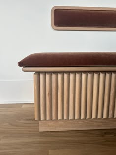 a wooden radiator sitting on top of a hard wood floor next to a white wall