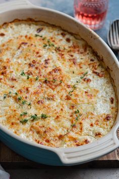 a casserole dish with cheese and parsley on the side, ready to be eaten