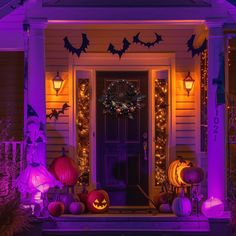 a house decorated for halloween with purple lights and pumpkins