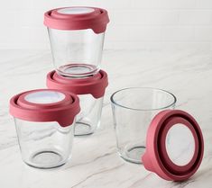 three glass tumblers with lids sitting on a marble surface