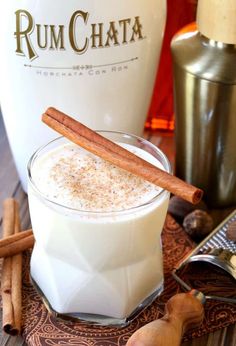 an image of a drink with cinnamon sticks on the rim and in front of it