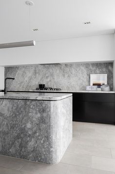 a kitchen with marble counter tops and black cabinets in the background, is featured on instagram