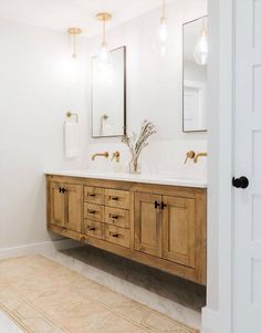 a bathroom with two sinks and mirrors in it