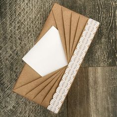 several brown envelopes with white lace on them