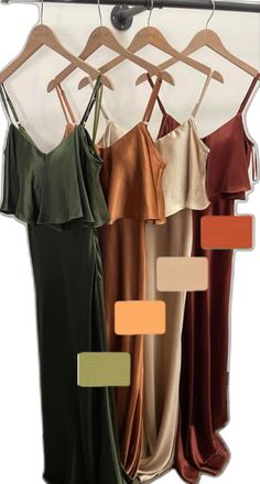 four dresses hanging on a clothes rack with different color swatches in front of them