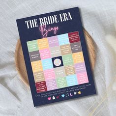 the bride era big book sits on top of a wooden plate with flowers in it