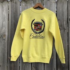 Vintage Cadillac crewneck raglan in rare yellow. Printed on Hanes sweat.  Reads Small  New/never worn condition without flaws or tags  Soft fleece inside  Measurements taken laying flat  Pit to pit 18  Length 26.5 Yellow Long Sleeve Sweater With Ribbed Cuffs, Yellow Cotton Crew Neck Sweater, Retro Crew Neck Sweatshirt With Ribbed Cuffs, Retro Yellow Sweatshirt For Winter, Retro Yellow Crew Neck Sweater, Yellow Crew Neck Winter Tops, Yellow Crew Neck Sweatshirt For Fall, Yellow Crew Neck Cotton Sweater, Yellow Winter Sweatshirt With Ribbed Cuffs