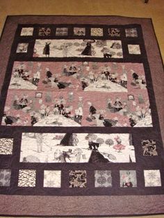 a black and white quilt on the floor with an image of people holding umbrellas