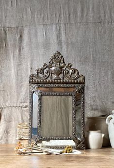 a mirror sitting on top of a wooden table next to vases and other items