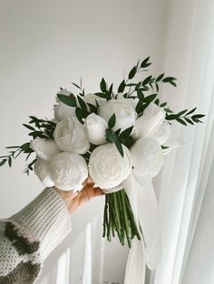 a person holding a bouquet of white flowers