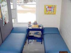 a room with two blue benches and a small table in the corner next to it