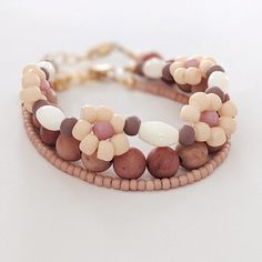 two stranded bracelets with beads and flowers on white background, close up view