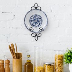 an assortment of kitchen utensils and spices on a shelf in front of a white brick wall