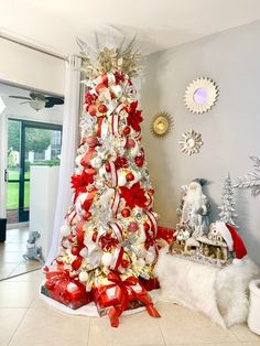 a christmas tree decorated with red and white ribbons in a living room area next to a window