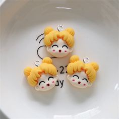 three little yellow and white dolls sitting on top of a white plate next to each other