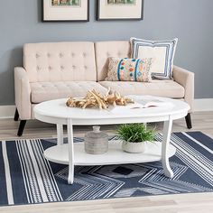 a living room with a couch, coffee table and two framed pictures on the wall