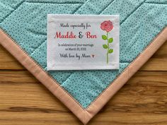 a blue and white quilted place mat with a pink rose on it that says made especially for maddika & ben