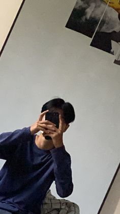 a man taking a selfie in front of a mirror with his cell phone up to his face