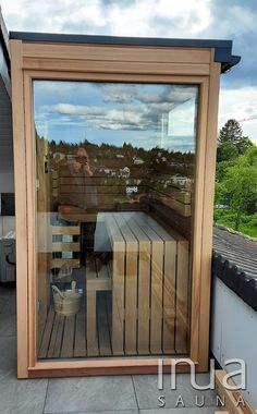 a person sitting at a table on top of a wooden deck next to a window