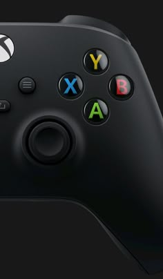 a close up shot of the back side of a black xbox controller with several different colored buttons