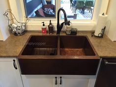 a kitchen sink sitting under a window next to a counter