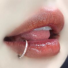 a woman's lips with a diamond ring on her lip, close up shot