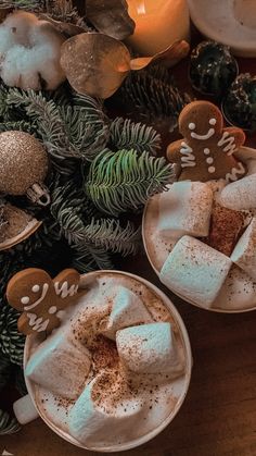 two white plates topped with marshmallows and gingerbread cut into small shapes