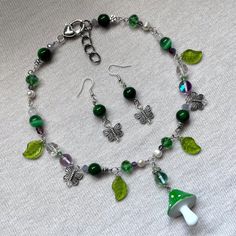 a necklace and earring set with green glass beads, silver plated charms and shamrocks