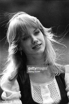 an old black and white photo of a woman with long blonde hair wearing a sweater