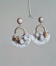 "Boho Handmade Raffia embellished white and gold wedding hoop earring. These boho wedding earrings are one of the most beautiful and one of the rare workmanship on any handmade earrings. The hoop earrings are made of multiple elements like tiny seed beads of white, gold, and fringes of raffia. The tiny seed bead balls and flowers are made with patience and aligned to make them look great for Wedding Jewellery. The gold color is used as an accent. The Earrings measure about approx. 3.10\" long an Handmade Adjustable Pearl White Earrings, Handmade Round Flower Earrings For Wedding, Bohemian Beaded Drop Bridal Earrings, Delicate Handmade Hoop Earrings For Wedding, Bohemian Beaded Bridal Drop Earrings, Bohemian Beaded Bridal Earrings, Bohemian White Beaded Earrings, White Bohemian Dangle Jewelry, Bohemian White Dangle Jewelry