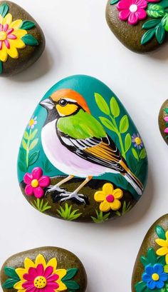 painted rocks with flowers and birds on them