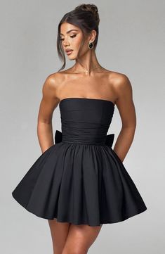 THE dress of the season has landed and you're going to be obsessed. Meet Katrina, our dreamy mini with a pretty, voluminous skirt and waist cinching bodice. Fastening with a zip to the back, tie with an oversized bow to complete the look for perfect feminine drama. 



Colour: Black.

Premium non-stretch cotton blend fabric.

Fully lined.

Strapless ruched bodice with boning.

Waist cinching.

Oversized tie to create bow detail to back.

Voluminous skirt with tulle lining.

Zip fastening to the reverse.

Mini length.

 Size: XS, S, M, L, XL, XXL Cocktail Dress With Gathered Voluminous Skirt, Cocktail Dress With Voluminous Gathered Skirt, Evening Dresses With Ruched Voluminous Skirt, Mini Corset Dress With Pleated Bodice For Night Out, Prom Mini Dress With Pleated Bodice, Spring Dresses With Gathered Waist And Full Skirt, Spring Dress With Gathered Waist And Full Skirt, Flirty Cocktail Dress With Pleated Bodice, Pleated Bodice Mini Dress For Prom