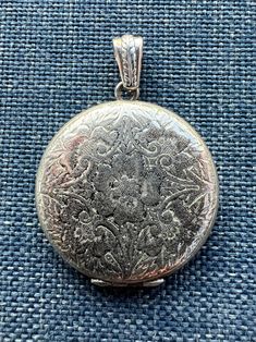 The center of this beautiful sterling silver sweetheart locket depicts a wild rose surrounded by decorative stems and flowers - such a pleasing and romantic design!  This locket is from the 1970's and is marked "BAB Sterling" on the interior of the locket.  The locket is round measures 1 1/4" in diameter.   The hinge is in working order with some visible scuffs to the finish. It is in very good vintage condition with some wear on the back, which is engraved "Love 1-24-72 L.G.E." The sterling silver bail is not original to the locket. Cowgirls and Saints gift box included. Etched Designs, Romantic Design, Wild Roses, Beautiful Rose, Locket Necklace, Beautiful Roses, Vintage Sterling Silver, Locket, Jewelry Necklaces