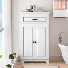 a white bathroom with a tub, sink and toilet next to a wall mounted air freshener dispenser