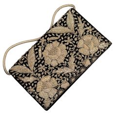 Elevate your evening attire with this beautiful clutch, a piece of history that seamlessly combines traditional craftsmanship with timeless style. This exquisite 1950s vintage Mughal clutch purse, a true masterpiece of Indian craftsmanship. Showcasing intricate hand embroidery, meticulously crafted with silver thread in the traditional Zardozi style, renowned for its luxurious and detailed embellishments .Embroidery is set against a rich black velvet base, which highlights the stunning metallic Embroidered Evening Bag For Festivals, Formal Festive Evening Bag With Gold Embroidery, Festive Formal Evening Bag With Gold Embroidery, Elegant Evening Bag For Receptions And Festivals, Traditional Evening Clutch With Intricate Embroidery, Traditional Embroidered Evening Bags, Designer Embroidered Evening Bag, Elegant Embroidered Ceremonial Bags, Formal Clutch With Intricate Embroidery For Festivals