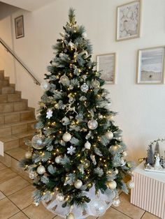 a decorated christmas tree with silver and white ornaments