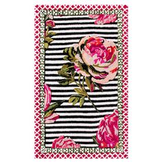 a black and white striped rug with pink flowers on it