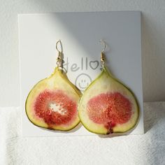 a pair of fruit shaped earrings sitting on top of a card